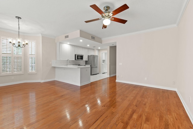 114 Radcliffe Ct, Jupiter, FL 33458 - unfurnished living room with ornamental molding, a sink, a chandelier, a ceiling fan, and light wood-type flooring