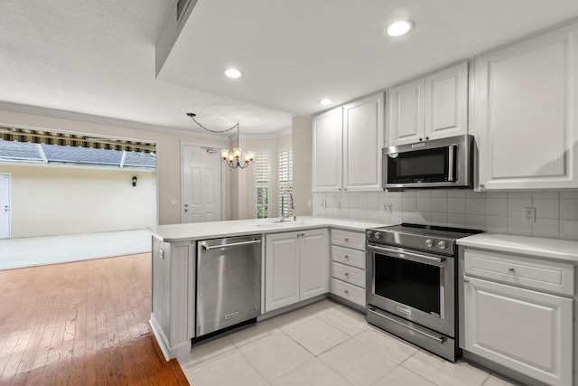 kitchen with a sink, tasteful backsplash, appliances with stainless steel finishes, and light countertops