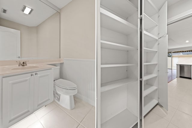 114 Radcliffe Ct, Jupiter, FL 33458 - bathroom featuring tile patterned floors, toilet, vanity, and wainscoting