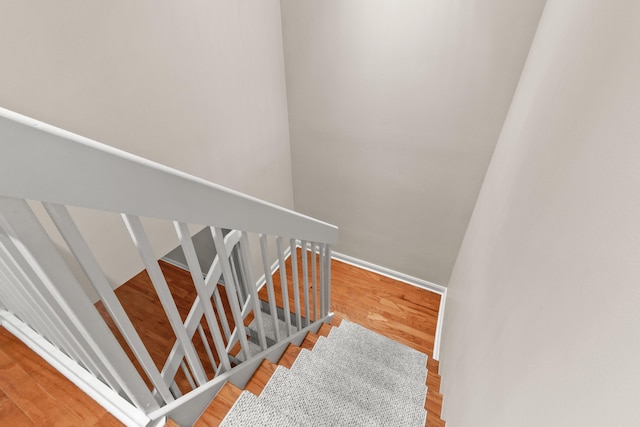 stairs with wood finished floors and baseboards