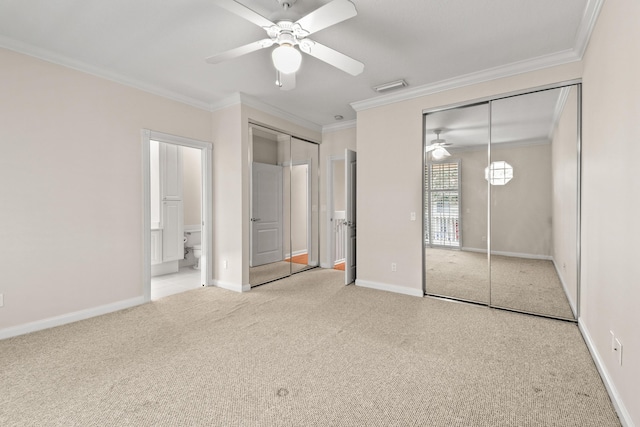 unfurnished bedroom featuring visible vents, two closets, ornamental molding, carpet flooring, and baseboards