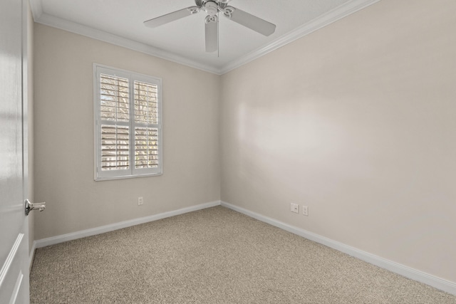 carpeted spare room with a ceiling fan, crown molding, and baseboards