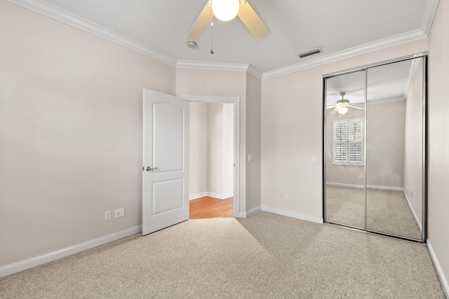 unfurnished bedroom with carpet flooring, visible vents, a closet, and ornamental molding