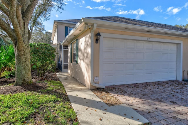114 Radcliffe Ct, Jupiter, FL 33458 - view of home's exterior featuring stucco siding, decorative driveway, and roof with shingles