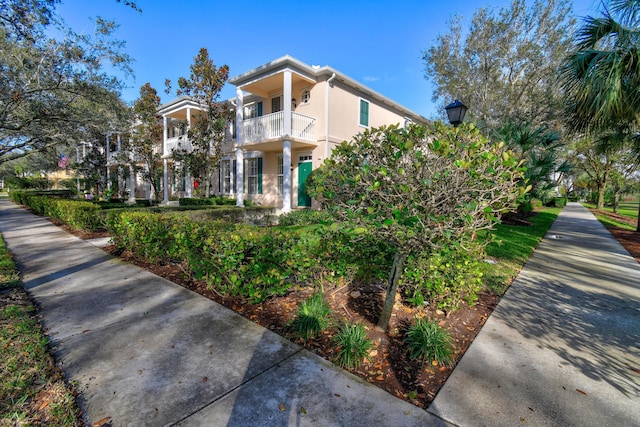 view of side of property with stucco siding and a balcony