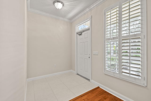 entrance foyer with light tile patterned floors, baseboards, and ornamental molding