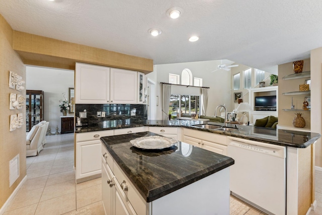 kitchen featuring a peninsula, white dishwasher, ceiling fan, a sink, and open floor plan