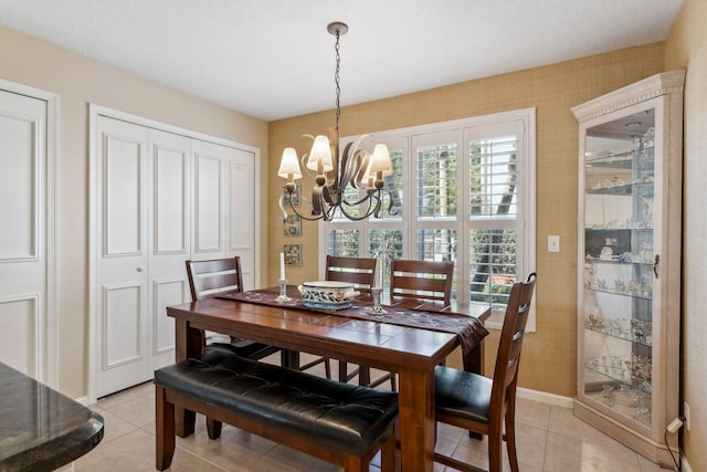 dining room with light tile patterned floors, baseboards, and an inviting chandelier