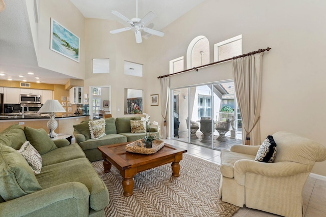 living area featuring light tile patterned floors, baseboards, and a ceiling fan