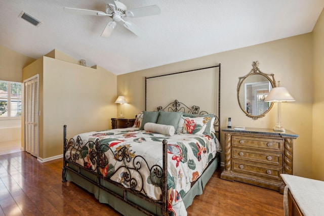 bedroom with lofted ceiling, wood finished floors, visible vents, and a closet