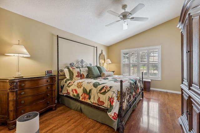 bedroom featuring a textured ceiling, wood finished floors, baseboards, and vaulted ceiling