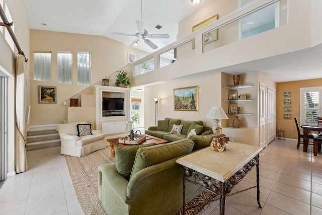 living area featuring light tile patterned floors, baseboards, high vaulted ceiling, and ceiling fan