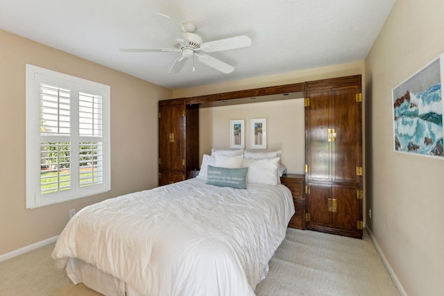 bedroom featuring baseboards, light carpet, and ceiling fan