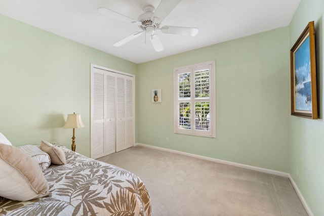 carpeted bedroom featuring a closet, ceiling fan, and baseboards