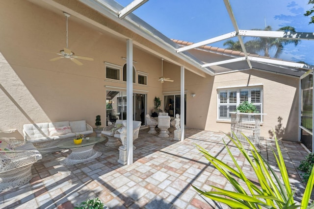 view of patio / terrace featuring an outdoor living space, a ceiling fan, and a lanai