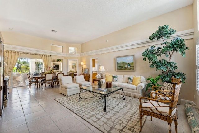 living area featuring light tile patterned flooring and visible vents