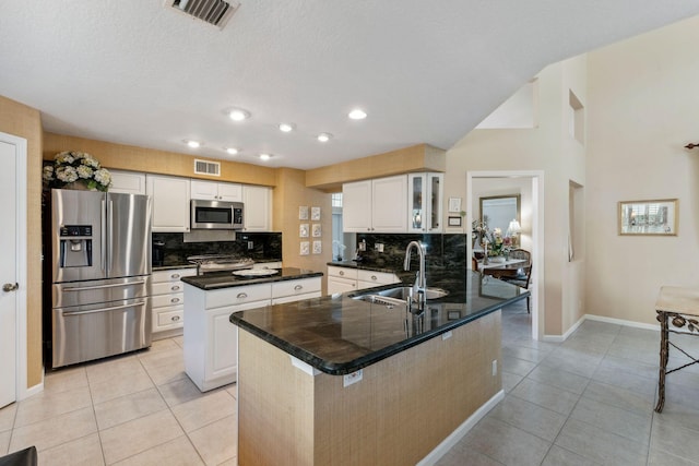 kitchen featuring visible vents, a sink, a kitchen island, stainless steel appliances, and light tile patterned flooring