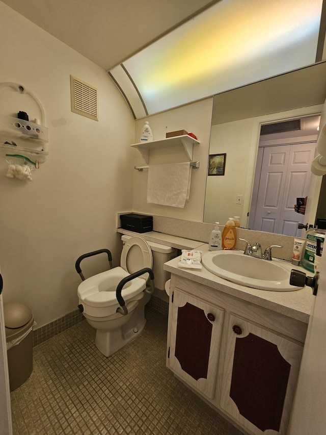 half bathroom featuring tile patterned flooring, visible vents, toilet, lofted ceiling, and vanity