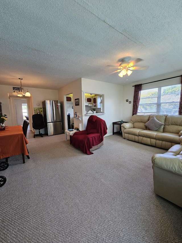 living room featuring a textured ceiling, ceiling fan, and carpet floors