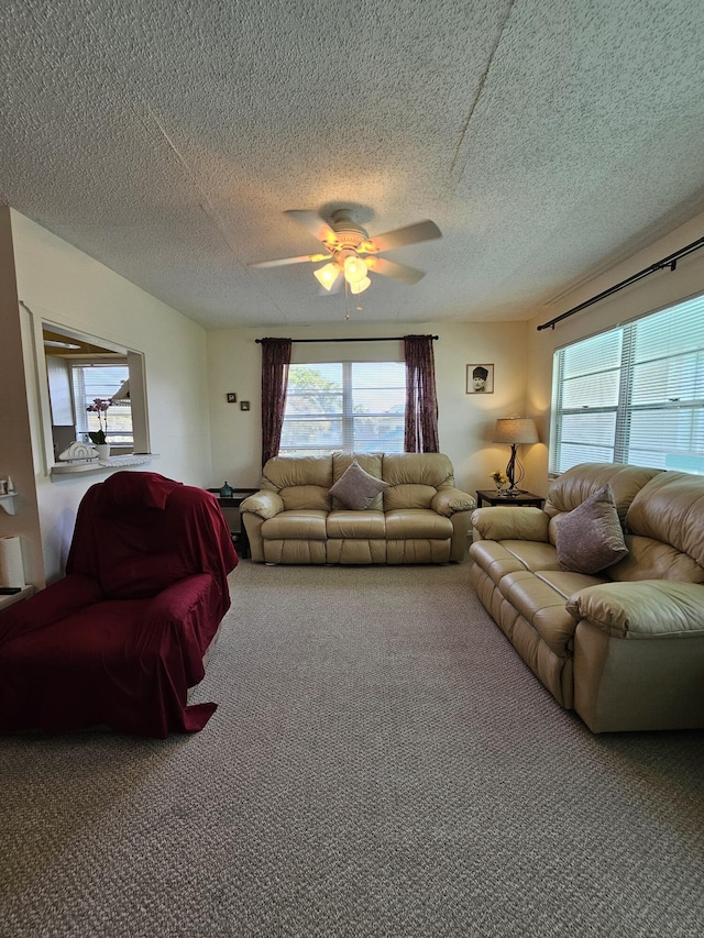 living room featuring a wealth of natural light, carpet floors, a textured ceiling, and ceiling fan