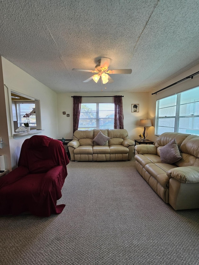 carpeted living area with a textured ceiling and a ceiling fan