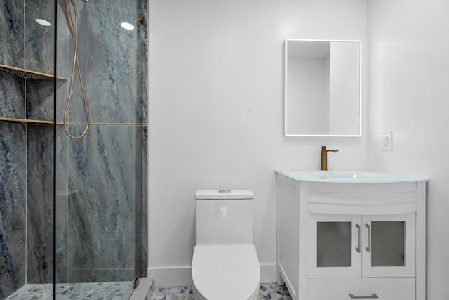 bathroom featuring a marble finish shower, toilet, vanity, and baseboards