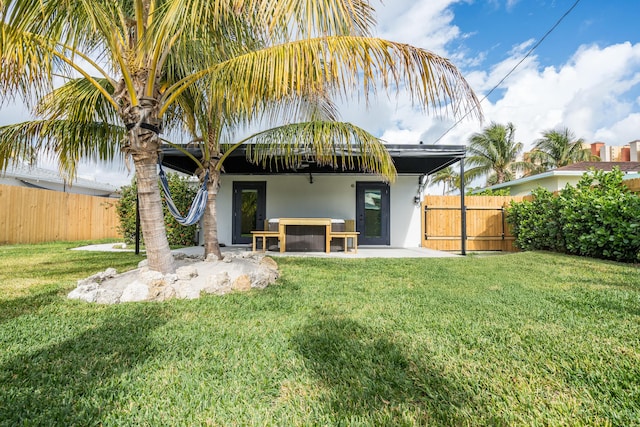 back of house featuring stucco siding, fence, a yard, and a patio area