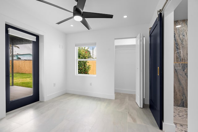 unfurnished bedroom featuring access to exterior, baseboards, a barn door, recessed lighting, and a ceiling fan