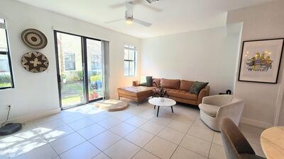 living room with light tile patterned flooring, baseboards, and a ceiling fan