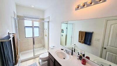 bathroom featuring a shower stall, toilet, and vanity