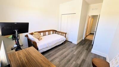 bedroom with a closet, baseboards, and wood finished floors