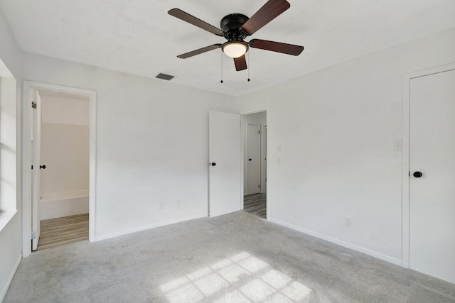 unfurnished bedroom with carpet floors, baseboards, ensuite bath, and visible vents