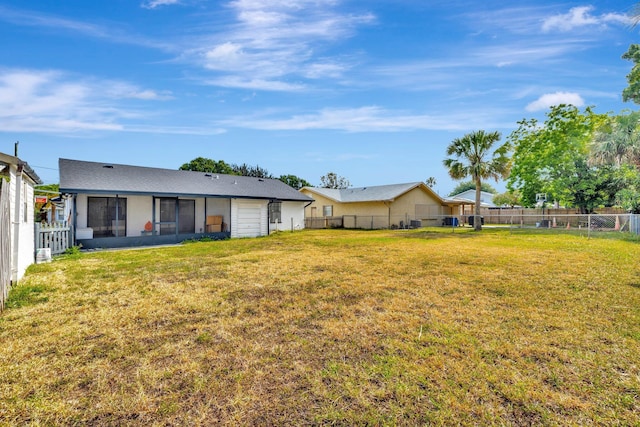 rear view of property with a lawn and fence