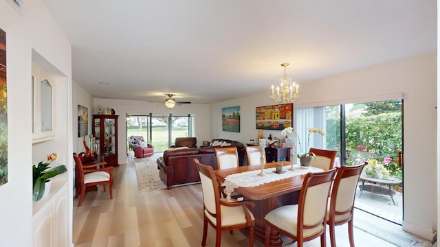 dining room with light wood-style flooring and ceiling fan with notable chandelier