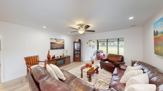 living area with a ceiling fan, recessed lighting, light wood-style floors, and baseboards