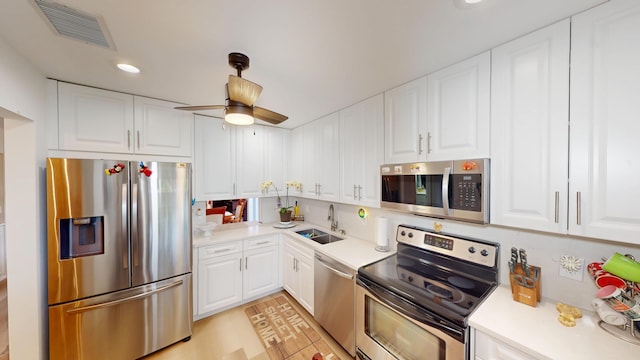 kitchen featuring visible vents, a sink, white cabinetry, stainless steel appliances, and light countertops