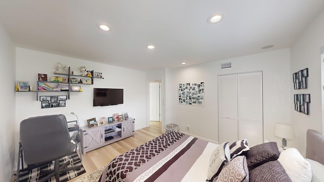 bedroom featuring a closet, recessed lighting, visible vents, and light wood finished floors