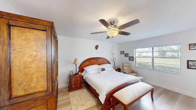 bedroom with light wood-style flooring, baseboards, and ceiling fan