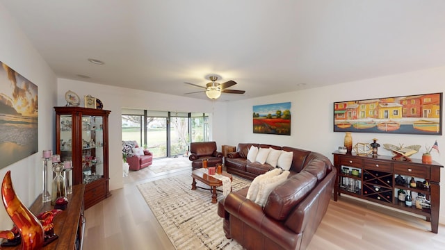 living room with light wood-type flooring and ceiling fan