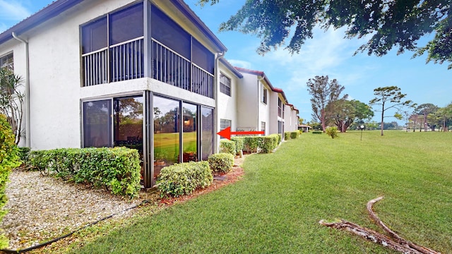 rear view of property with a yard and stucco siding