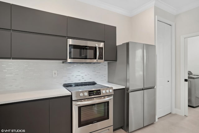 kitchen featuring tasteful backsplash, appliances with stainless steel finishes, washer / clothes dryer, and light countertops