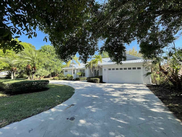 view of front of property featuring concrete driveway, an attached garage, and stucco siding