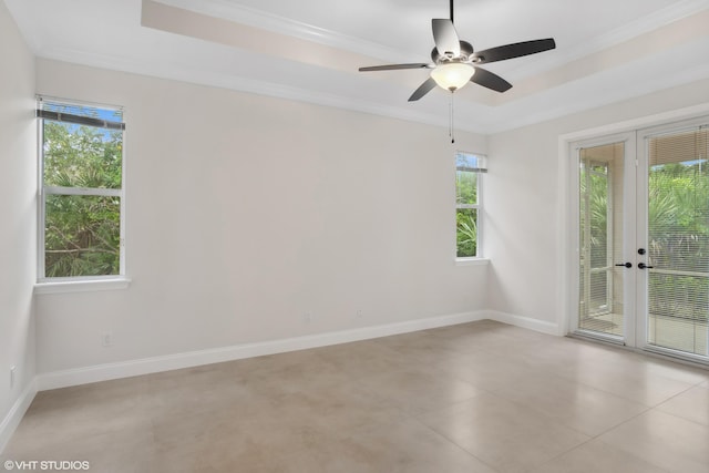 empty room featuring crown molding, a raised ceiling, and baseboards