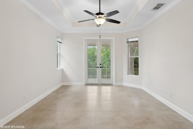 empty room featuring visible vents, crown molding, baseboards, a tray ceiling, and french doors