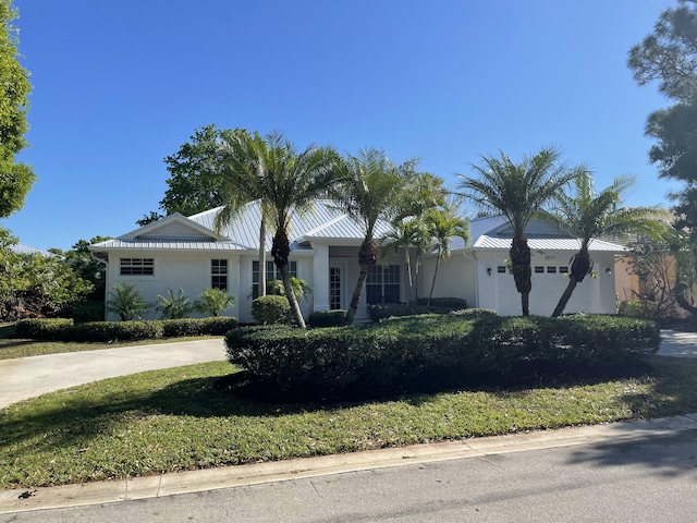 single story home with a standing seam roof, stucco siding, metal roof, and a garage