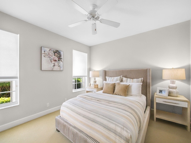 bedroom with baseboards, light colored carpet, and a ceiling fan