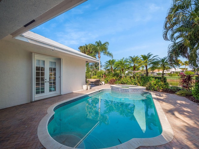 view of swimming pool featuring french doors, a patio, a pool with connected hot tub, and fence