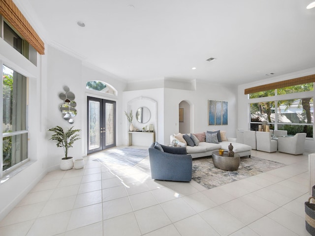 living area with light tile patterned flooring, a healthy amount of sunlight, visible vents, and ornamental molding