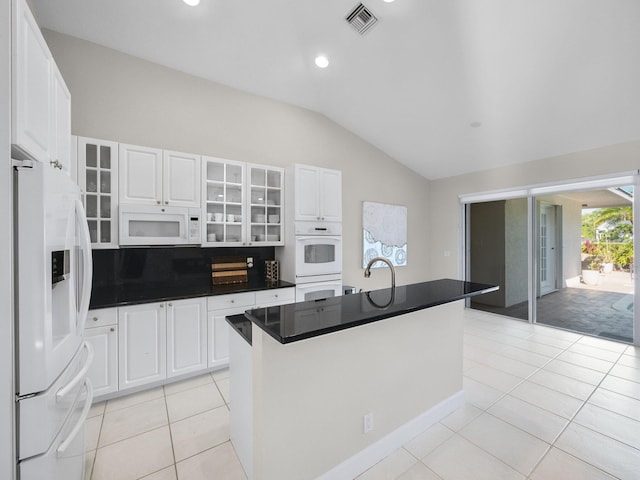 kitchen with white appliances, visible vents, light tile patterned flooring, vaulted ceiling, and white cabinetry