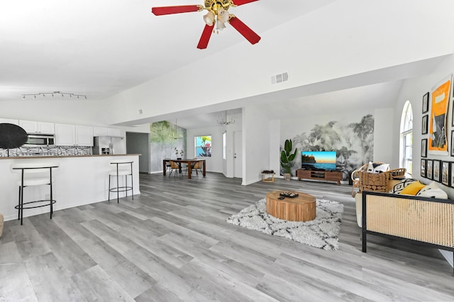 7492 SW 40th Ter, Palm City, FL 34990 - living room featuring light wood finished floors, a ceiling fan, and high vaulted ceiling